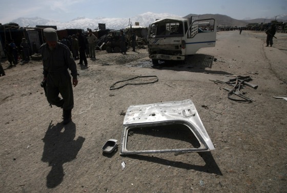 An Afghan police officer surveys the damage after an explosion on the outskirts of Kabul on Sunday. A suicide bomber targeted a NATO patrol, but killed two Afghan civilians instead.